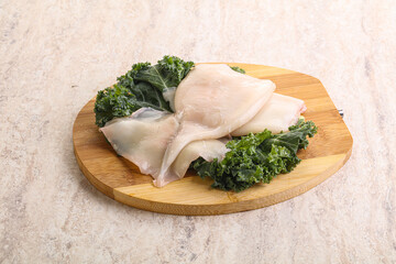 Raw squid over wooden board