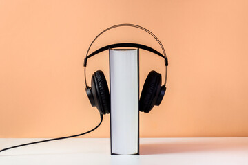 Headphones on book. Audiobook horizontal banner with copyspace. Online education and e-learning...