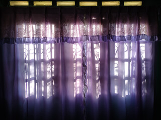 Purple window curtains that have been installed in the living room.