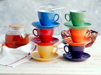 Obraz na płótnie Canvas Bright multi colored tea cups cheer you up. Porcelain kitchen utensils.