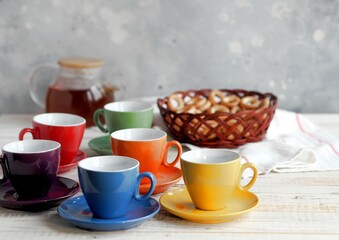 Bright multi colored tea cups cheer you up. Porcelain kitchen utensils.