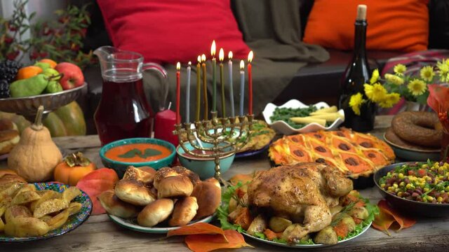 Prayers and lighting the Hanukkah menorah. Hanukkah Blessings. Jewish Holiday. Traditional festive kosher food on the table