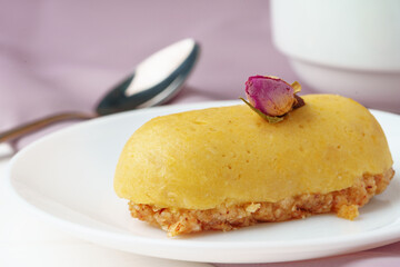 Mini mousse pastry dessert with rose on white plate