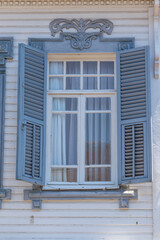 Window with wooden shutters on white wall building, Turkey