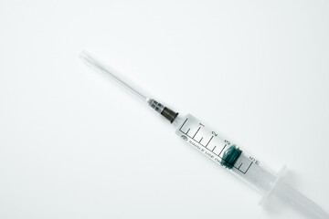 Medical syringe and needle with medicament on a light background
