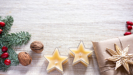 Christmas card with bee wax star candles, nuts recycled paper gift wrap, red berries. Minimalist...