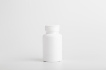 Jar of pills isolate. White plastic jar for medical pills, drugs and vitamins on a blank white background.