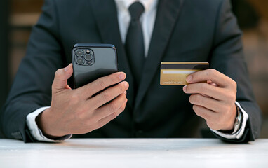 Businessman in suit holding smartphone and credit cade.