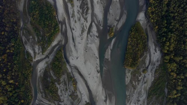 Aerial view of Laba river valley at dawn in autumn, Mostovskoy, Krasnodar Krai, Russia. Picturesque landscape, nature of Caucasus from drone. River flood, orange trees, stony coast snowy shore.