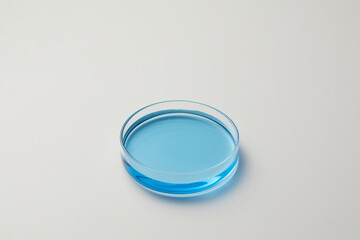 Petri dishes with blue water and ripple in grey background