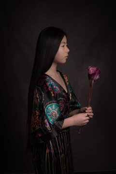 Classic studio portrait of asian woman with calyx flower in dark rembrandt style