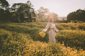 Young attractive woman having fun in yellow flower field