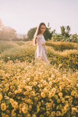 Fototapeta na wymiar Young attractive woman having fun in yellow flower field