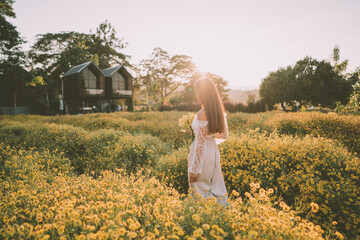 Young attractive woman having fun in yellow flower field