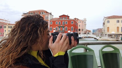 Europe, Venice - young girl taking pictures in Venezia from the boat  - tourism resumes with the...