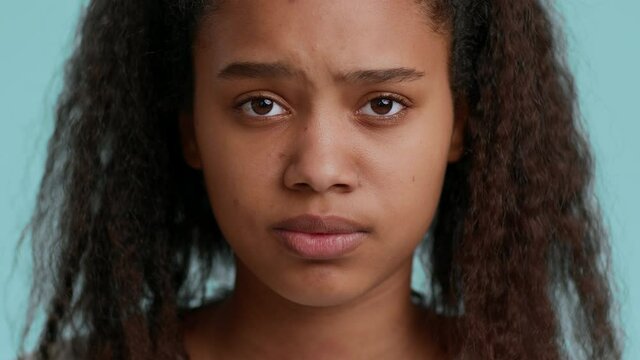 Depressed African American Teenager Girl Posing Over Blue Background