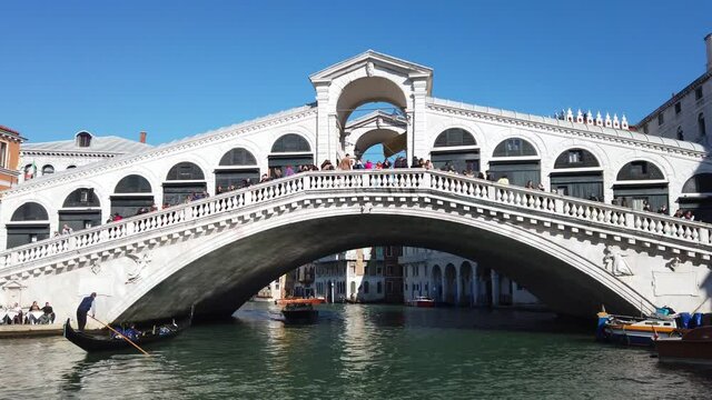 Europe, Italy, Venice November 2021 - Gondolas in Canal Grande with tourist and gondolier in Rialto bridge famous attraction in city of love 