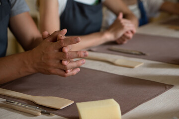 Hands of people working in pottery workshop