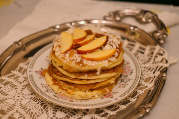 Stack of American apple  pancakes with jam, nuts and apples