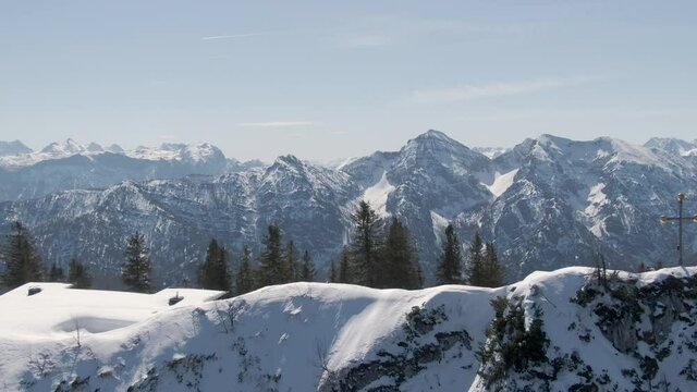 Aerial Drone flight along the peak of the Rauschberg in Bavaria, Chiemgau with a beautiful Parallax effect and the cross on top.