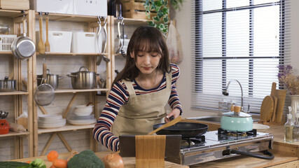 korean woman replaying the online cooking tutorial on tablet, trying to catch up. lady new to...