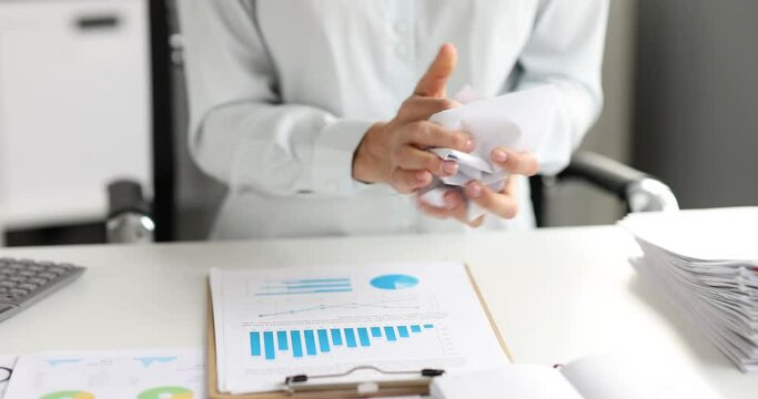 Female hands crumpling paper document and throwing it in office closeup 4k movie slow motion
