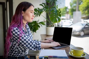 Woman typing on notebook with blank screen with copy space for your text or advertising content, sitting at wooden table