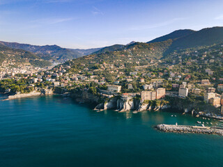 Fototapeta na wymiar Aerial view of Italian coastline. Genova area, Camogli city. City next to the big cliffs. Mediterranean sea in liguria coast. 