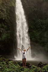 woman posing against the backdrop of a waterfall.