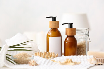 Spa set with bottles of cosmetics on light background