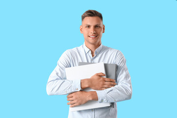 Young man with folders on color background