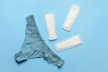 Menstrual pads and panties on blue background