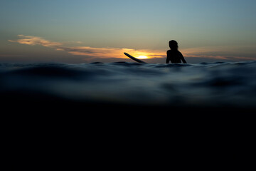 beautiful girl with a surfboard at sunset.