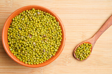 Green gram or mung bean in bowl over wooden background.
