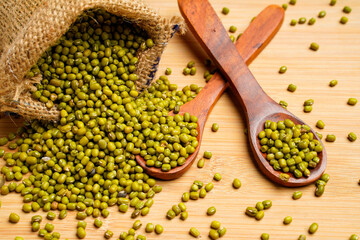 Green gram or mung bean in wooden spoon over wooden background.