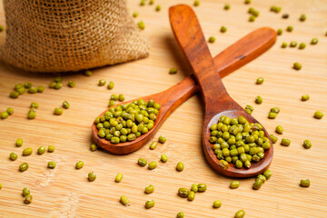 Green gram or mung bean in wooden spoon over wooden background.