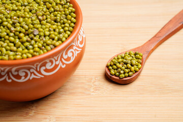 Green gram or mung bean in bowl over wooden background.