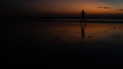 Fototapeta premium beautiful girl runs along the beach at sunset