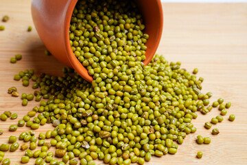 Green gram or mung bean in bowl over wooden background. - obrazy, fototapety, plakaty
