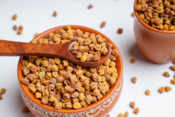 Dry chickpea in bowl and wooden spoon.