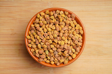 Dry chickpea in bowl on wooden background