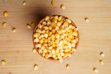 dried corn seeds in bowl on white background.