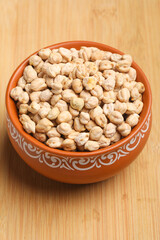 Dry chickpea in bowl on wooden background.