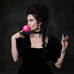 Classic retro portrait of young beautiful woman in image of medieval royal person in black dress...