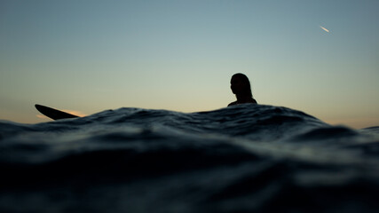 beautiful girl with a surfboard at sunset.