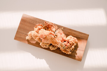 Fried chicken on a wooden plate.