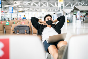 New Normal and travel bubble concept.COVID-19 Travel Airport Asian man tourist boarding plane for holiday wearing medical face mask protection Coronavirus disease (Covid-19) infection in airport