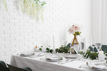 Beautiful table setting for wedding celebration with burning candles in restaurant