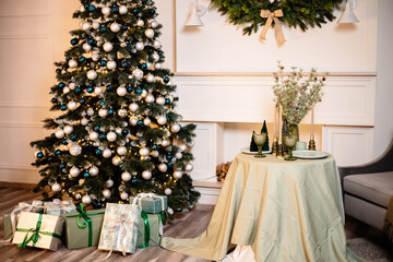 Warm cozy beautiful modern room design in gentle light colors decorated with a Christmas tree and decor elements for the new year