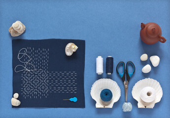 Sashiko hand embroidery in Japanese style with white threads on a blue cotton fabric on a blue...